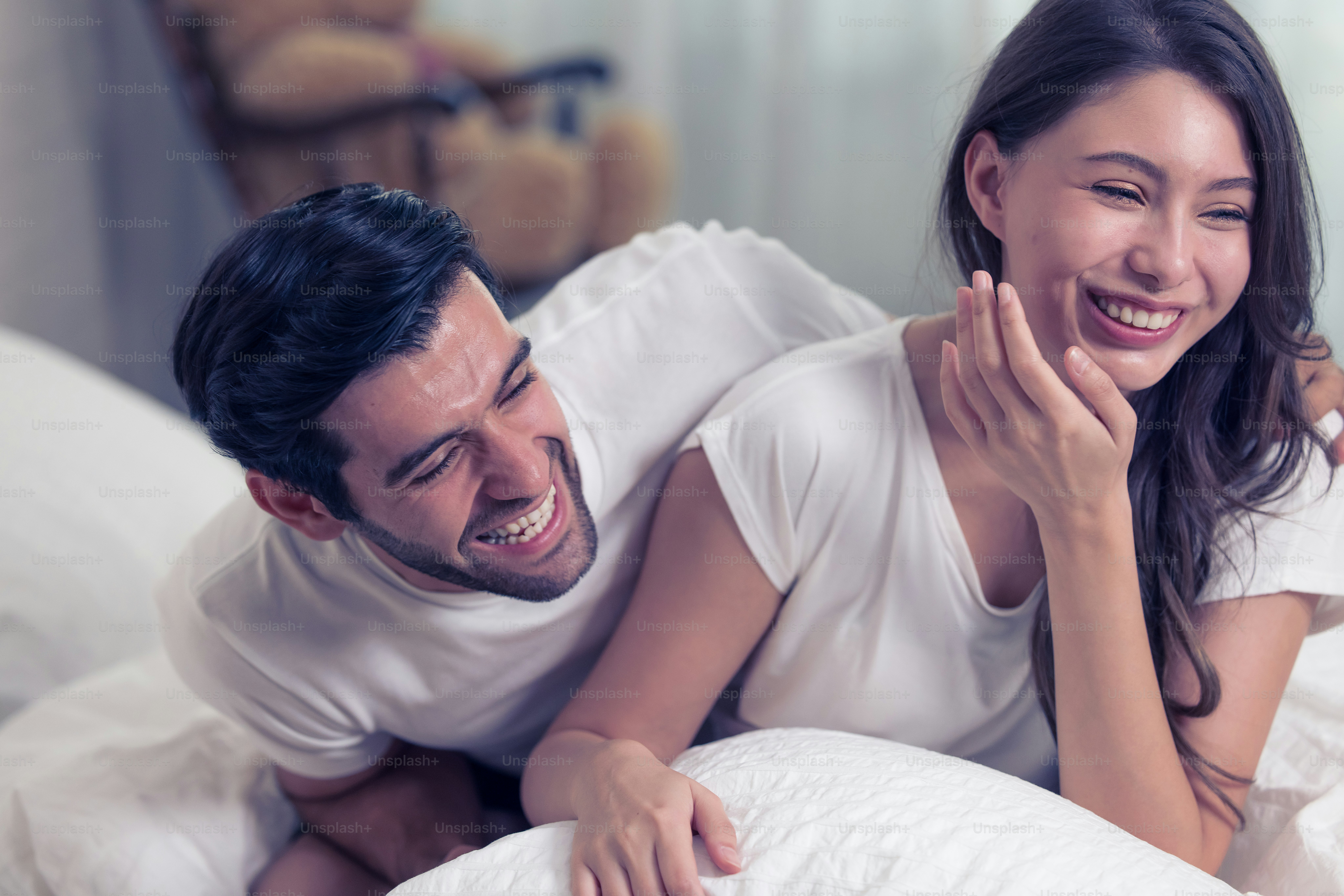 Young loving couple lying on the bed, enjoying